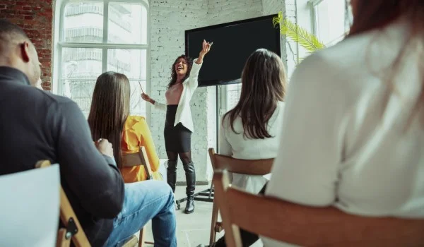 Una mujer dando una presentación frente a un grupo.