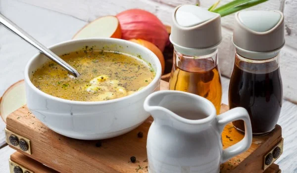 Un plato de sopa con recipientes para salsas y condimentos