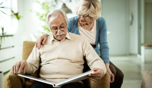 Una pareja de ancianos mirando un álbum de fotos.