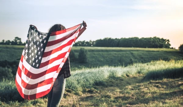 Persona levantando una bandera de Estados Unidos