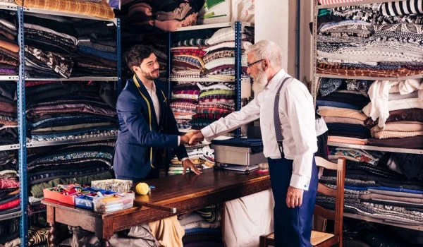 Dos hombres saludándose dentro de una tienda de edredones local