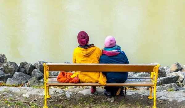 Mujeres migrantes sentadas en una banca