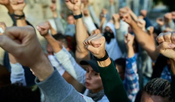 Personas levantando sus puños en protesta por sus derechos