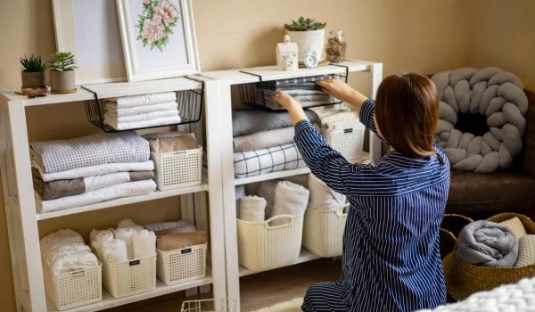 Mujer organizando toallas, sábanas en su hogar