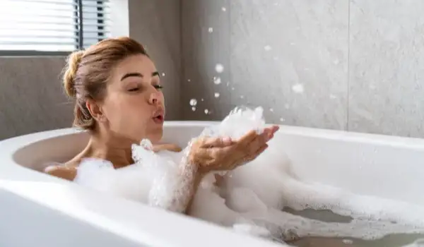 Una mujer disfruntando de un baño de burbujas