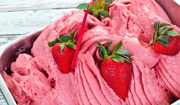 Helado de fresa con fresas enteras encima