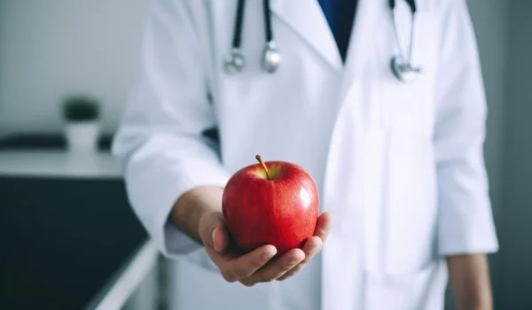 Un nitriólogo con una manzana en su mano