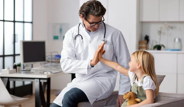 Un doctor choca los cinco con un niño