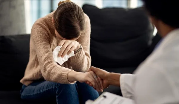 Mujer deprimida llorando frente a un médico